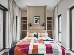 柏林numa I Nook Rooms & Apartments的一间卧室配有一张大床和五颜六色的被子