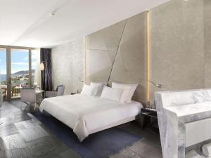 图尔古特雷斯博德鲁姆海滩瑞士度假酒店的卧室配有一张白色大床和一张书桌