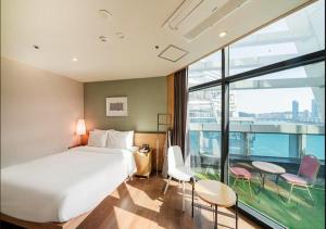 釜山Gwangalli Hotel primavera in Busan的酒店客房设有一张床和一个大窗户