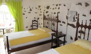 LombaVivenda Flores - Casa Hortensia的一间卧室设有两张床和绿帘