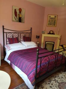 Ségur-le-ChâteauLes Charrons的一间卧室配有一张大床和紫色毯子
