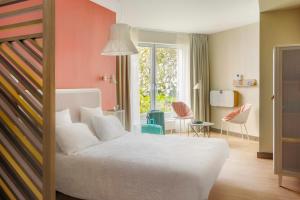 里尔OKKO Hotels Lille Centre的卧室配有一张床和一张桌子及椅子