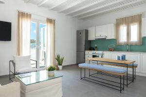 米克诺斯城Amperian Mykonos Suites & Villas的一间带桌子的客厅和一间厨房