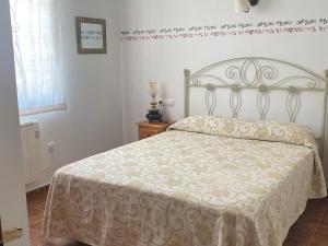 奥萨德蒙铁尔Casa Rural Villa Lucia的一间卧室配有一张带白色床罩的床