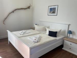 奥斯赛拜-塞林Pension Villa Frohsinn Sellin auf Rügen的白色的床、白色床单和枕头