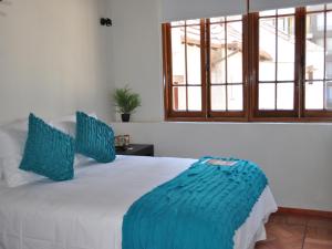 圣地亚哥Hotel CasaDeTodos的一间卧室配有白色床和蓝色枕头