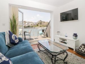 普里茅斯2 Beach Cottage的客厅配有蓝色的沙发和玻璃桌