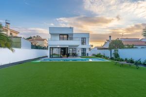林孔-德拉维多利亚Villa swimming pool Malaga的白色的房子,设有大院子和绿色草坪