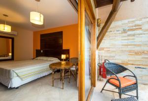 尼西亚弗洛雷斯塔Praia Bonita Resort & Conventions - Praia de Camurupim的卧室配有一张床和一张桌子及椅子