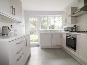 布德Sea Salt的白色的厨房配有白色橱柜和窗户