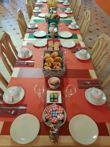 Reilhac阿里尔河酒店的一张长桌,上面放有盘子和碗的食物