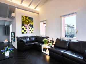 博洛尼亚OBERDAN SUITE Appartamento nel cuore di Bologna的客厅配有黑色真皮沙发