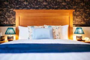 奇德尔Pymgate Lodge Hotel Manchester Airport的一张带木头床头板和两盏灯的床