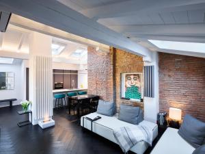 博洛尼亚OBERDAN SUITE Appartamento nel cuore di Bologna的一间带砖墙和沙发的客厅