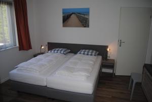 东卡佩勒Villa Dunopark 49的卧室配有两张床,墙上挂着一幅画
