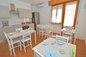 阿尔巴·阿德里亚蒂卡B&B Linae - Residence的厨房以及带白色桌椅的用餐室。
