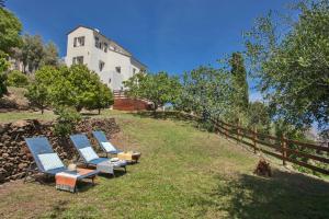 Santa-Maria-di-Lotavita nova的坐在房子旁边的山丘上的一组椅子
