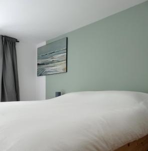 沙尔内卡Surf & Kite - Villa Nortada的卧室内的一张白色床,墙上挂着一幅画