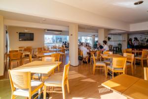 马德普拉塔Bristol Apart Hotel的餐厅设有木桌和椅子,客人坐在桌子旁
