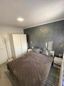 帕利克Apartmani Mira的一间卧室设有一张大床和灰色的墙壁