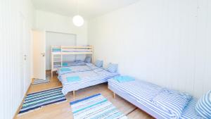 ValklaPuhkekeskus Valkla Rand- Simple accomodation的蓝色和白色条纹的客房内的三张床