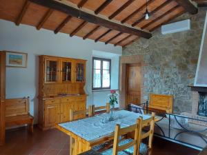 巴尼奥维尼奥尼Agriturismo Capannacce的一间设有桌子和石墙的用餐室