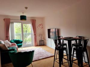 沃灵顿Emerald Blossom-Central Warrington, Luxurious Yet Homely, WiFi, Secure Parking的客厅配有桌椅和电视。