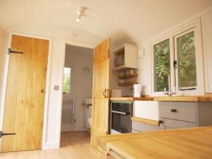 哈斯奥科斯Wolstonbury Getaway的厨房配有白色橱柜和木制台面