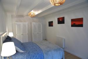 PloulechAux Arbres Chanteurs的一间卧室配有蓝色的床和两盏灯