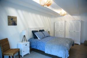 PloulechAux Arbres Chanteurs的一间卧室配有一张带蓝色被子和椅子的床