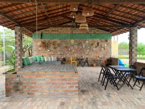 圣阿马鲁Quintal de Areias的一个带砖墙和桌椅的庭院