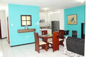 曼塔Departamentos de 2 y 3 Habitaciones en el Centro de MANTA的厨房配有桌椅和蓝色的墙壁