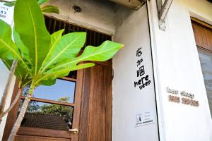 高雄底加睏-眷村民宿的植物旁的有标志的门
