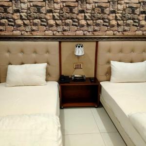 拉希迈尔汗Golden Sand Hotel Rahim Yar Khan的配有一张床的酒店客房内的两张床tg