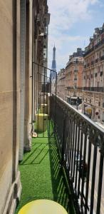 巴黎爱丽舍联合酒店的阳台享有绿色草地和城市美景。