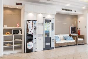 里乔内Hotel Amalfi - Smart Hotel的带沙发和冰箱的客厅