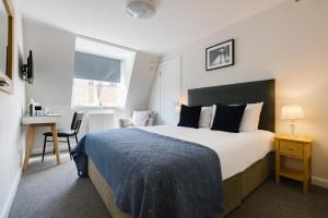 伦敦CitySpace Borough的一间卧室配有一张床、一张书桌和一个窗户。