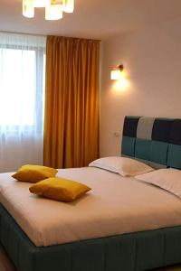 杜博瓦乡BLISS Dubova的一间卧室配有一张大床和两张黄色枕头