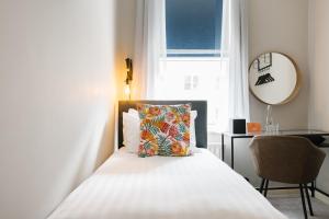伦敦CitySpace Borough的一间卧室配有一张带枕头和窗户的床