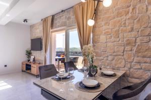 萨利TEONA Luxury Apartment with jacuzzi and terrace sea view的一间设有桌子和石墙的用餐室