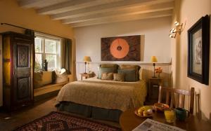 圣达菲拉斯帕洛马斯酒店的一间卧室配有一张床、一张桌子和一个窗户。