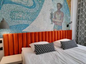 符拉迪沃斯托克SV Hotel的一间卧室配有橙色床头板和壁画