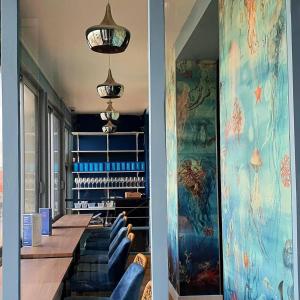 沙特拉永普拉日Hôtel Restaurant L'Atelier des Cousins的一间用餐室,配有蓝色的椅子和墙上的绘画作品