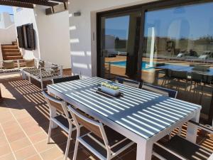 卡勒达德福斯特Villa BELLA on Golf in La Estancia, Caleta Fuste-Fuerteventura的天井上的蓝色桌椅