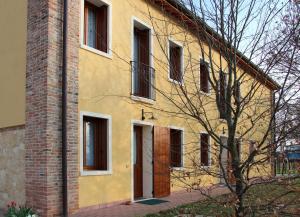 Montegalda法托瑞阿格利玛纳酒店的一座黄色的房子,有砖砌建筑