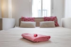 科尼尔-德拉弗龙特拉PRECIOSO Y PEQUEÑO LOFT CENTRO DE CONIL的床上的粉红色毛巾