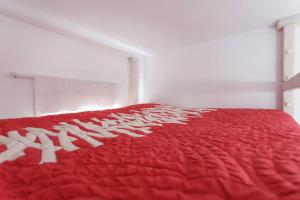科尼尔-德拉弗龙特拉PRECIOSO Y PEQUEÑO LOFT CENTRO DE CONIL的床上有红色的被子