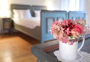 GnotzheimGentner - Hotel garni的卧室里的白色花瓶,桌子上放着鲜花
