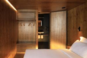 科英布拉Zero Box Lodge Coimbra的卧室配有白色的床和木墙