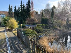 卡尔斯哈根Zur Alten Tischlerei的公园里有一个围栏,还有一个鸟儿池塘